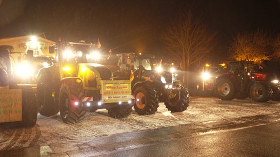 Mehrere Traktoren bei nächtlicher Demonstration am Fähranleger Schlüttsiel. © NDR 
