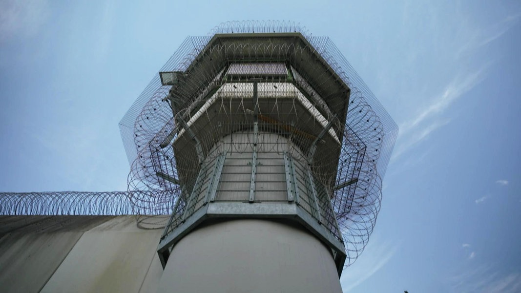 Ein Gefängnisturm mit Stacheldraht.