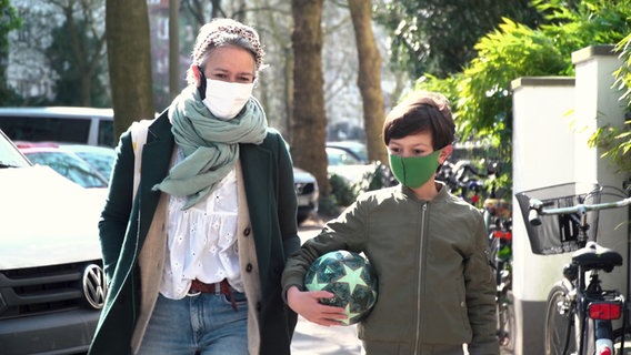 Mutter und Kind mit Atemschutzmasken  
