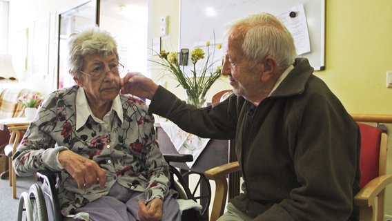 Ein alter Mann streichelt einer alten Frau die Wange © NDR Foto: Screenshot