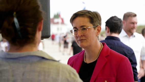 Karoline Preisler von der FDP  (Hintergrund) im Gespräch mit einer Frau - Videovariante © NDR Foto: Screenshot
