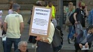 Demonstrant gegen die Corona-Maßnahmen in Hamburg mit Plakat gegen Impfmaßnahmen © NDR Foto: Screenshot