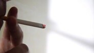 Ein Mann raucht eine Zigarette. © NDR 