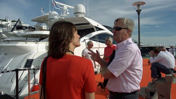 Reporterin Anna Orth (li.) spricht mit einem Sunseeker-Interessenten in Cannes. © NDR 