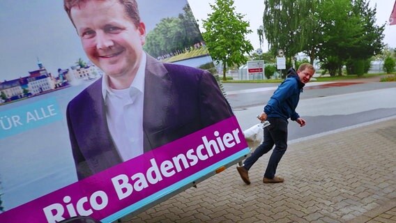 Rico Badenschier beim Plakat aufhängen © NDR 