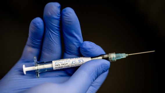 Eine Hand hält eine Spritze mit einem experimentellen Corona-Impfstoff. © dpa 