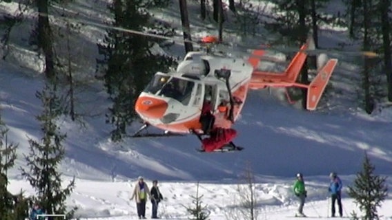Ein Hubschrauber birgt ein Todesopfer aus dem Tiefschnee.  