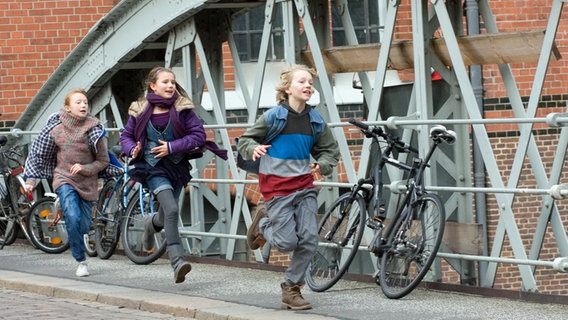 Emma, Nina und Max laufen über eine Brücke © NDR Foto: Claudia Timmann