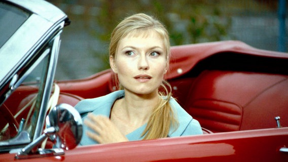 Eine blonde Frau sitzt in einem roten Cabrio © NDR 