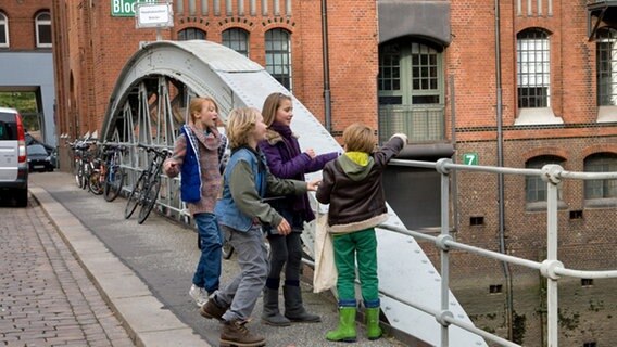 Henri, Emma, Max und Nina stehen an einem Brückengeländer © NDR Foto: Claudia Timmann