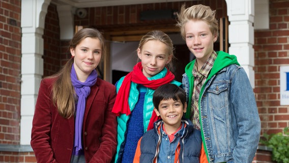 Die Pfefferkörner der 6. Generation, Nina, Jessi, Luis und Max stehen vor einer Eingangstür © NDR Foto: Claudia Timmann