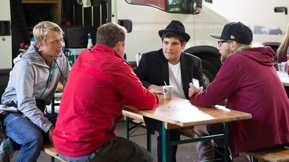 Anton (Danilo Kamber) sitzt mit drei Teamkollegen am Tisch. © NDR Foto: Claudia Timmann