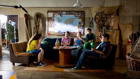 Ceyda (Merle de Villiers), Niklas (Jaden Dreier), Jessi (Martha Fries), Luis (Emilio Sanmarino) und  Anton (Danilo Kamber) sitzen im Hauptquartier in der Sofaecke. © NDR Foto: Claudia Timmann