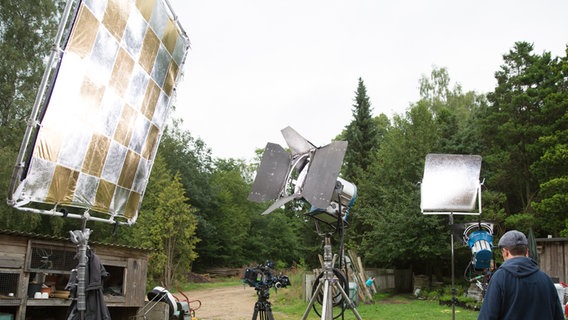 Vor einem Schuppen stehen Lampen und Reflektoren. © NDR Foto: Claudia Timmann