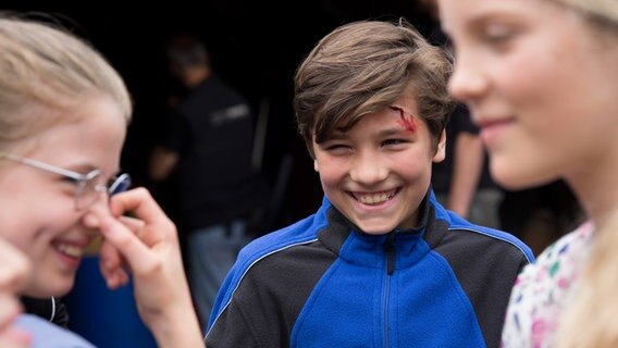Ramin (Jann Piet) mit einer geschminkten Wunde auf der Stirn. © NDR Foto: Claudia Timmann