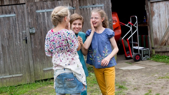 Stella (Zoë Malia Moon), Till ( Otto von Grevenmoor)  und Pinja (Sina Michel) stehen lachend zusammen. © NDR Foto: Claudia Timmann
