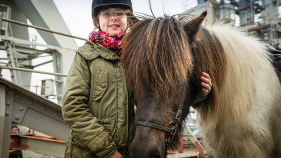 Pinja (Sina Michel) steht neben einem Pony an der Hafenkante. © NDR/StudioHH Foto: Boris Laewen
