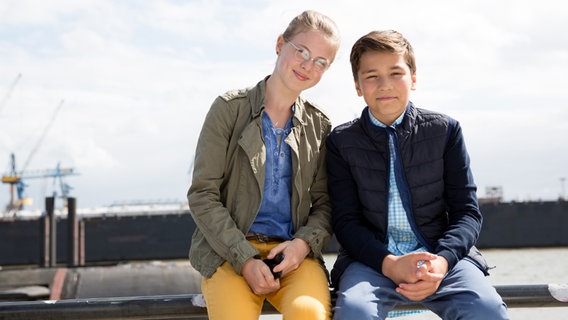 Pinja (Sina Michel) und Ramin (Jann Piet) sitzen am Hafen. © NDR Foto: Claudia Timmann