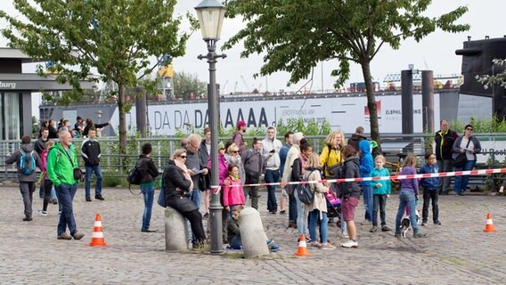 Fans stehen hinter einem Absperrband am Hafen. © NDR Foto: Claudia Timmann