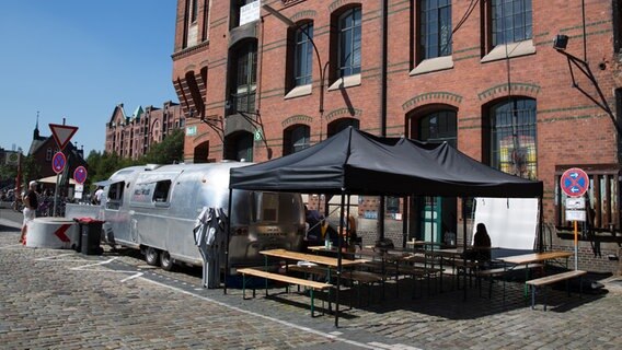 Ein Cateringwagen steht vor einem Speicherhaus. © NDR Foto: Claudia Timmann