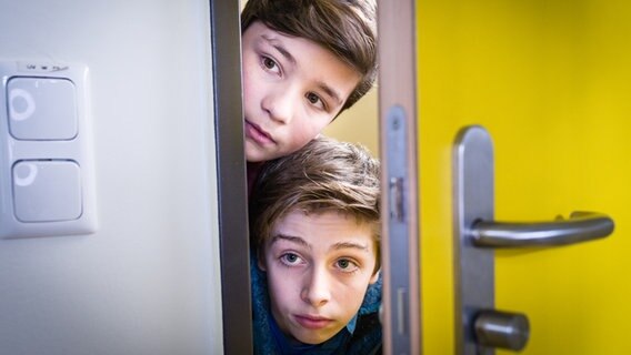 Ramin (Jann Piet) und Till (Otto von Grevenmoor) spähen durch eine geöffnete Tür. © NDR/Studio HH Foto: Boris Laewen