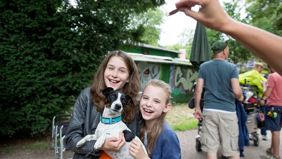 Mia (Marleen Quentin) und  Alice (Emily Flint) halten einen Hund auf dem Arm. © NDR Foto: Claudia Timmann