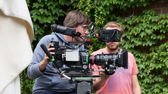 Zwei Kameramänner stehen um eine Kamera. © NDR Foto: Claudia Timmann