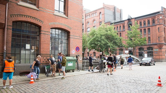 Das Filmteam steht auf einer Straße in der Speicherstadt. © NDR Foto: Claudia Timmann