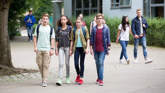 Johannis (Luke Matt Röntgen),Lisha (Emma Roth), Mia (Marleen Quetin) und Benny (Ruben Storck) gehen nebeneinander über den Schulhof. © NDR Foto: Claudia Timmann