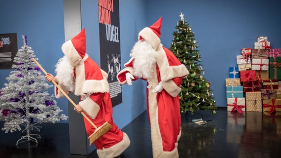 Zwei Weihnachtsmänner sind in der Weihnachtsausstellung unterwegs. © NDR/Studio HH Foto: Boris Laewen