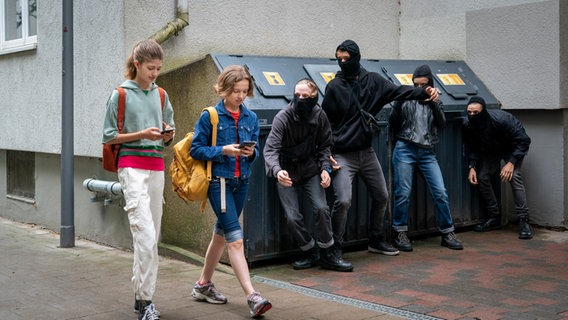 Lou und Tali auf dem Weg zur Schule, bei Mülltonnen lauert eine Gang. © NDR/Letterbox Foto: Boris Laewen