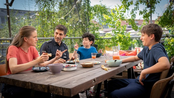 Freya, Nazim mit Milan und Rafa sitzen zusammen am Frühstückstisch © NDR/Letterbox Foto: Boris Laewen