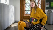 Pippa sitzt auf dem Schulflur in ihrem Rollstihl und versteht die Welt nicht mehr. Haben sich plötzlich alle gegen sie verschworen? © NDR/Letterbox Foto: Boris Laewen