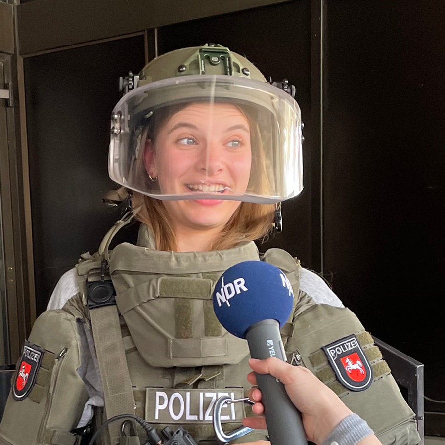 Emilia Flint trägt die Ausrüstung des SEK Niedersachen und wird interviewt. © Philip Hasse Foto: Philip Hasse / LKA Niedersachsen
