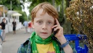 Henri hält ein Handy an sein Ohr © NDR/Romano Ruhnau 