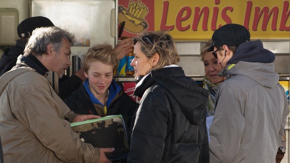 Das Team steht vor dem Imbiss mit Max und Oma Leni. © NDR Foto: Claudia Timmann