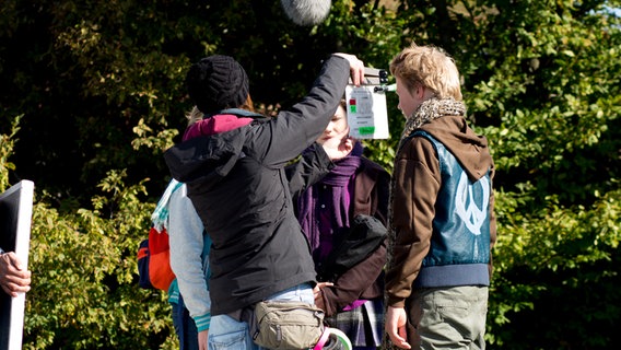 Eine Frau hält die Filmklappe zwischen Nina und Max. © NDR Foto: Claudia Timmann