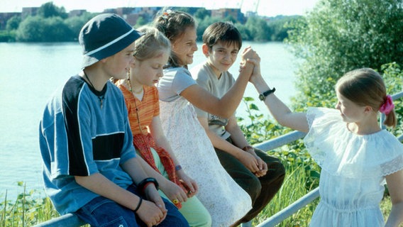 Die Pfefferkörner Fiete, Vivi, Jana, Cem und Natascha sitzen am See © NDR 