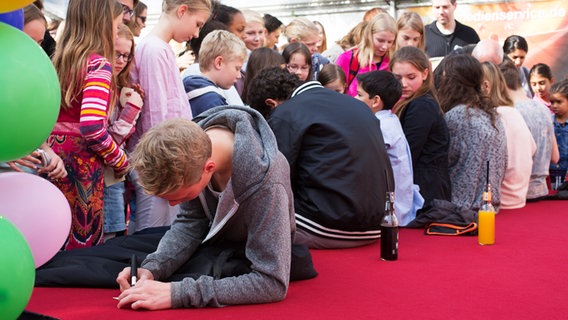 Junge Pfefferkornfans stehen wartend vor den Darstellern. © NDR Foto: Claudia Timmann