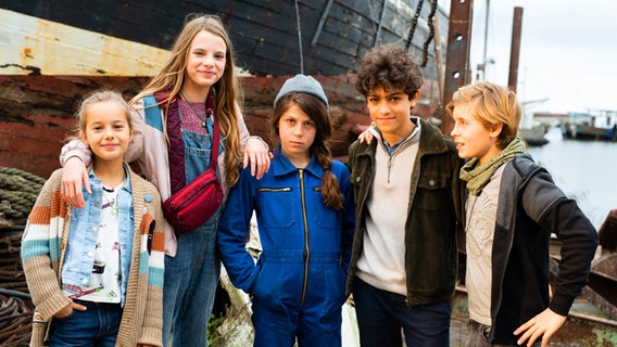 Gruppenbild mit Clarissa, Alice, Hanna, Tarun und Jonny vor einem alten Schiff. © NDR/Letterbox Foto: Marion von der Mehden
