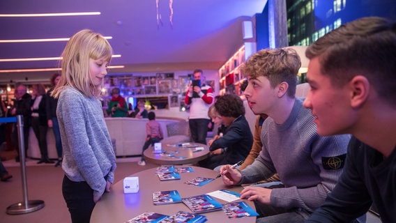 Till (Otto von Grevenmoor) und Ramin (Jann Piet) unterschreiben eine Autogrammkarte © NDR Foto: Axel Herzig