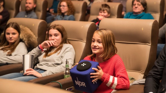 Ein Mädchen hält den NDR-Mikrofonwürfel in der Hand und stellt eine Frage. © NDR Foto: Axel Herzig