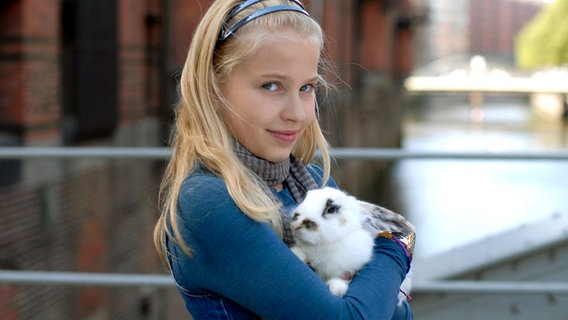Sophie (Katherina Unger) trägt ein Kaninchen auf dem Arm © NDR/Romano Ruhnau 