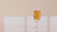 Ein gefülltes Bierglas steht auf einem Tisch.  