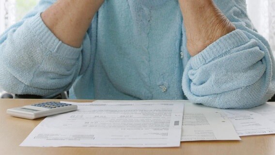 Ältere Frau schaut auf Rechnungen. © fotolia Foto: AnkeThomass