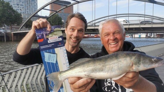 Ein Zander aus der HafenCity! Schauspieler und Hobbyangler Matthias Schloo (li) und NDR Angelexperte Horst Hennings im Glück. © NDR/Heinz Galling 