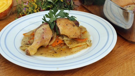 Entenkeulen mit Kartoffel-Möhren-Gemüse auf einem Teller serviert. © NDR Foto: Florian Kruck