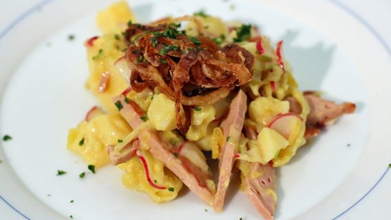 Kartoffelsalat mit Leberkäse und Röstzwiebeln auf einem Teller © NDR Foto: Florian Kruck