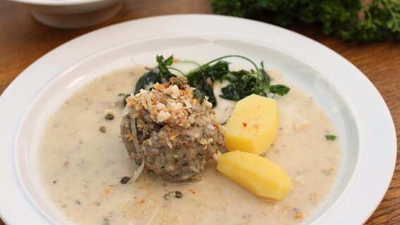 Königsberger Klops mit Kartoffeln und frittierter Petersilie auf einem Teller serviert © NDR Foto: Florian Kruck