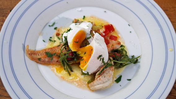 Seezungenfilets mit pochiertem Ei und einer Sahnesoße auf einem Teller serviert. © NDR Foto: Florian Kruck